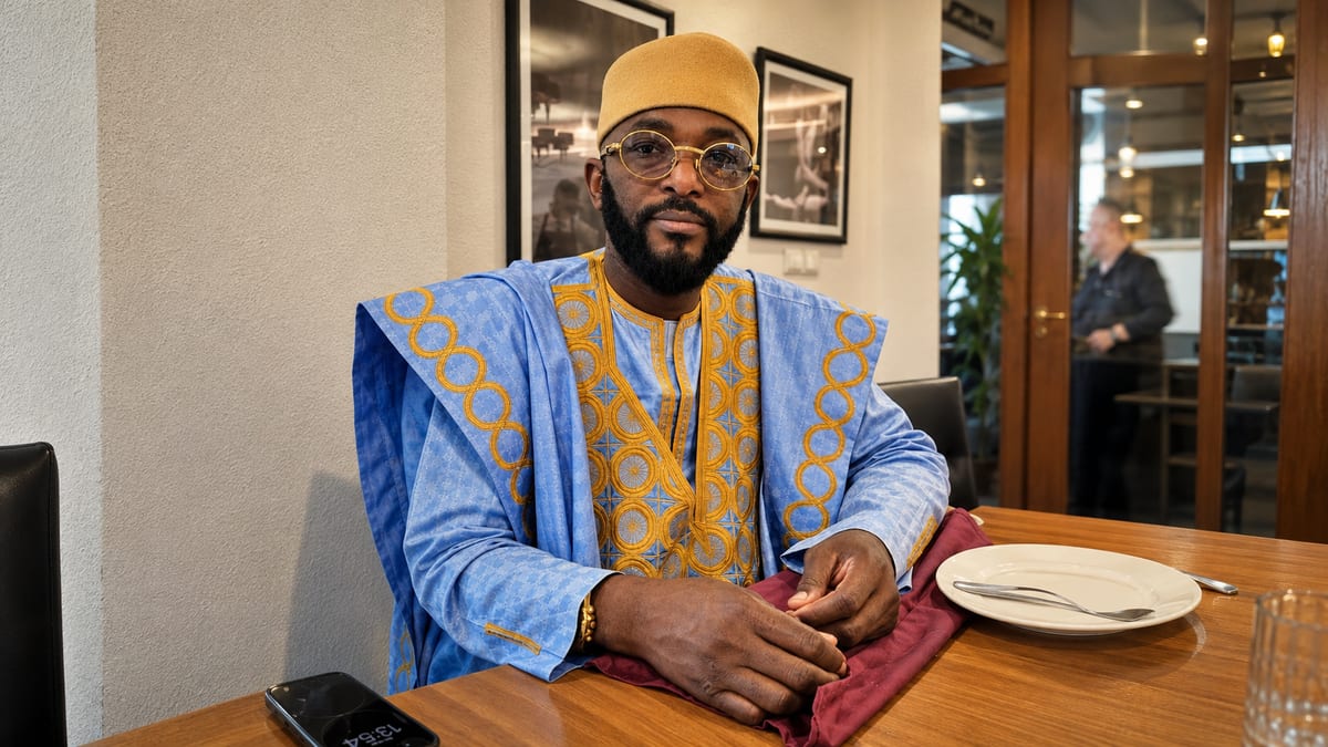 Marabout Djibril in a blue and gold boubou, seated in consultation